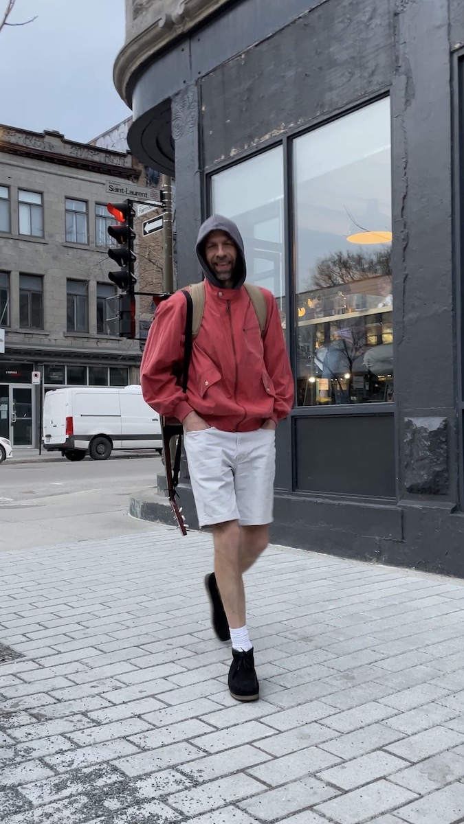 Jake Morgan walking through Mile End with guitar